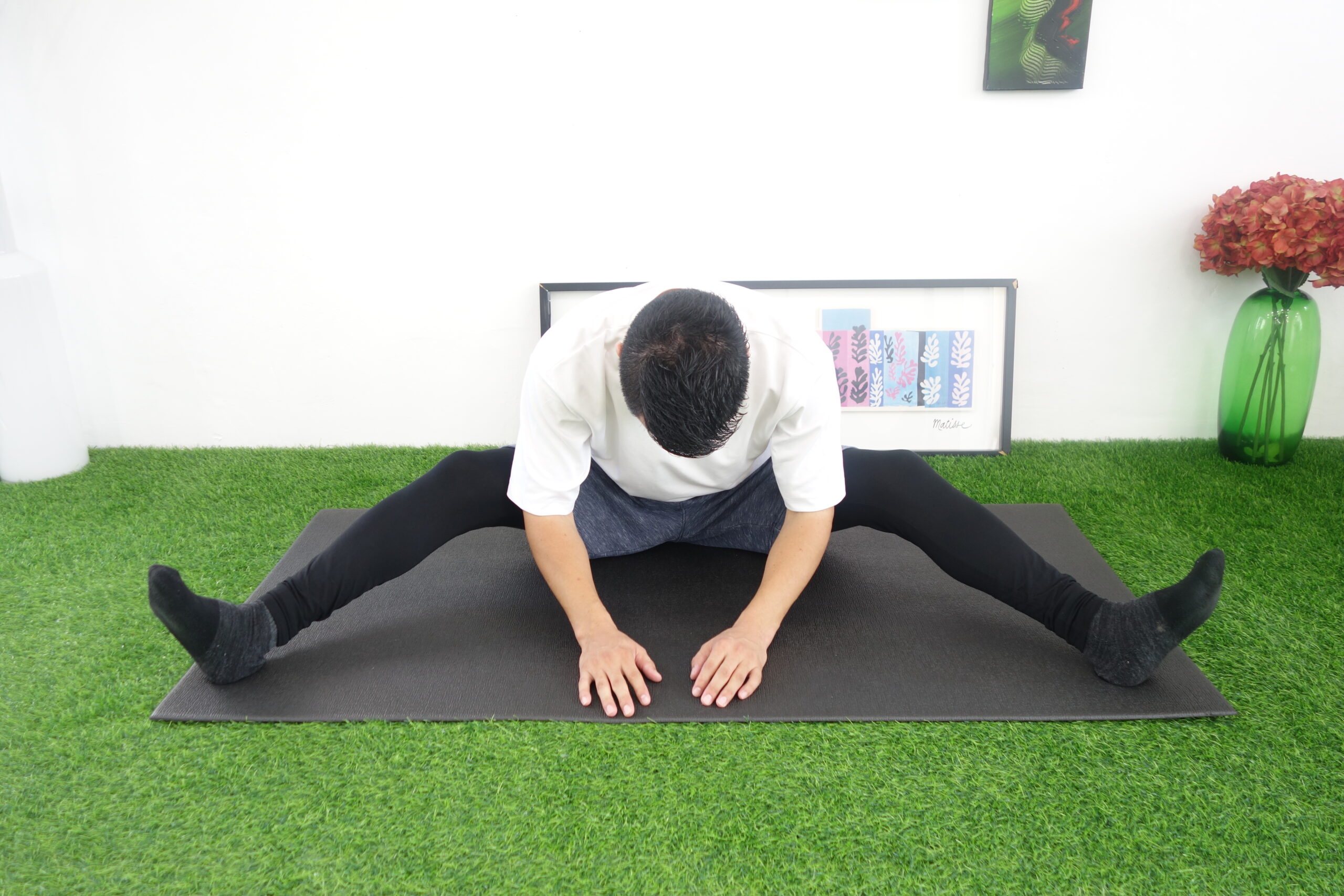 開脚して膝を曲げ、前屈する