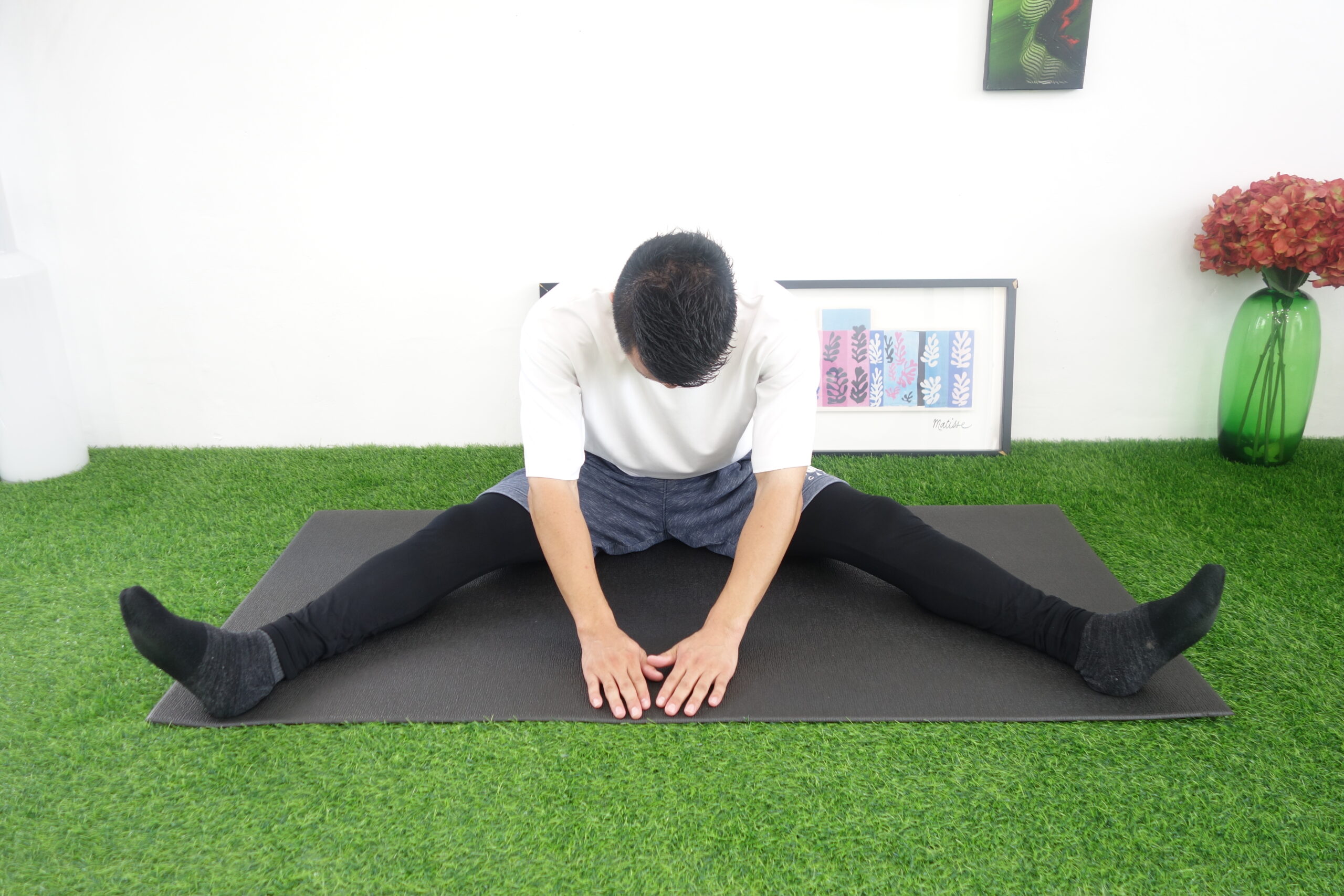 脚を伸ばした状態で開脚して前屈する