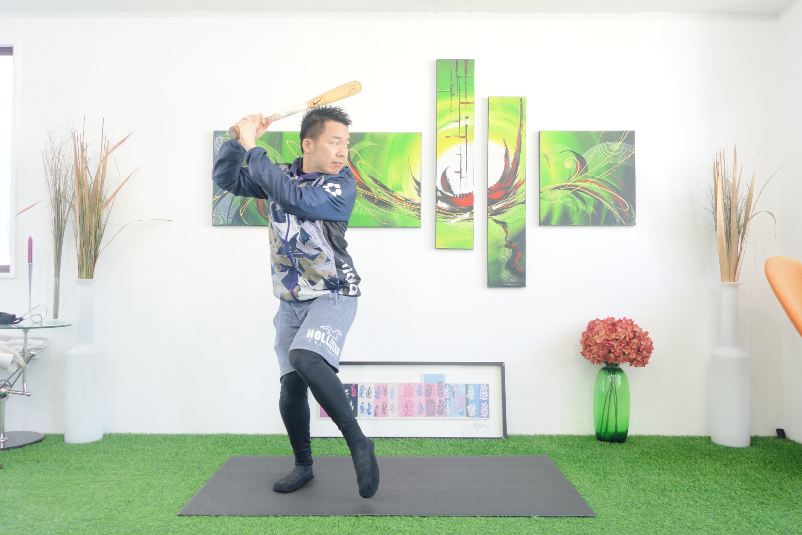 軸足に体重を乗せてバットを構える