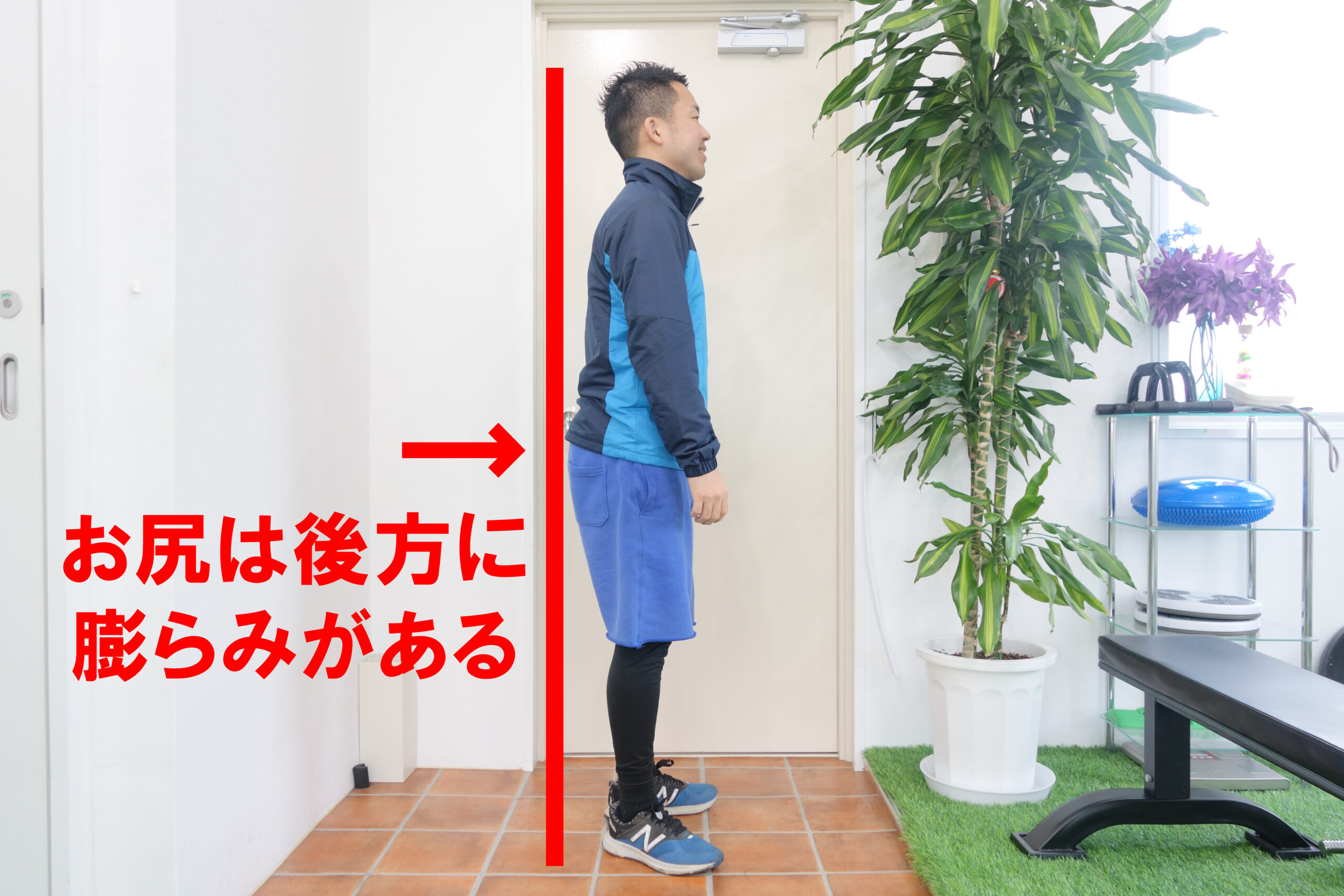 壁の前でお尻をつけた状態で立つ