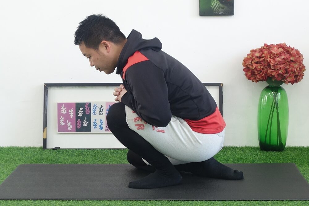 座った状態で片膝を立て、アキレス腱を伸ばすストレッチング